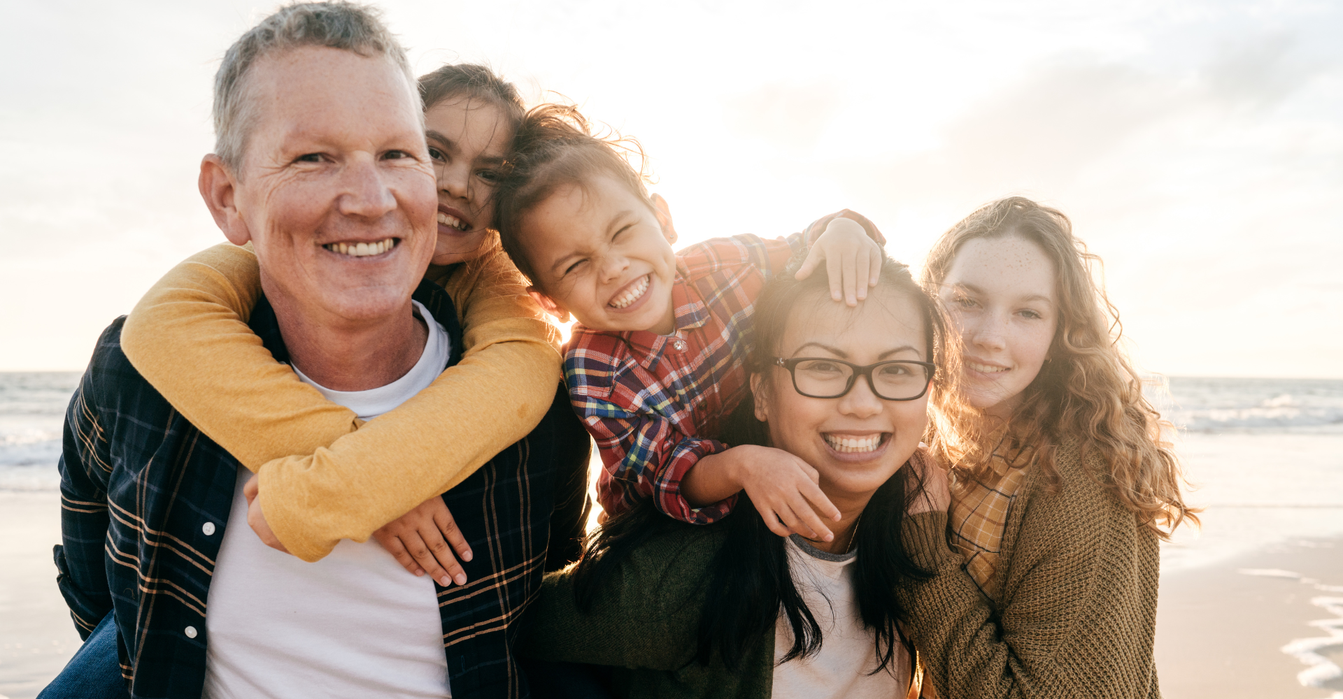 Happy vibrant smiling family by the beach