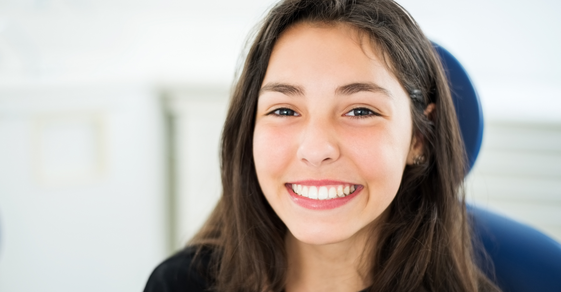 girl with a beautiful toothy smile sitting at Jordan Landing Dental Care